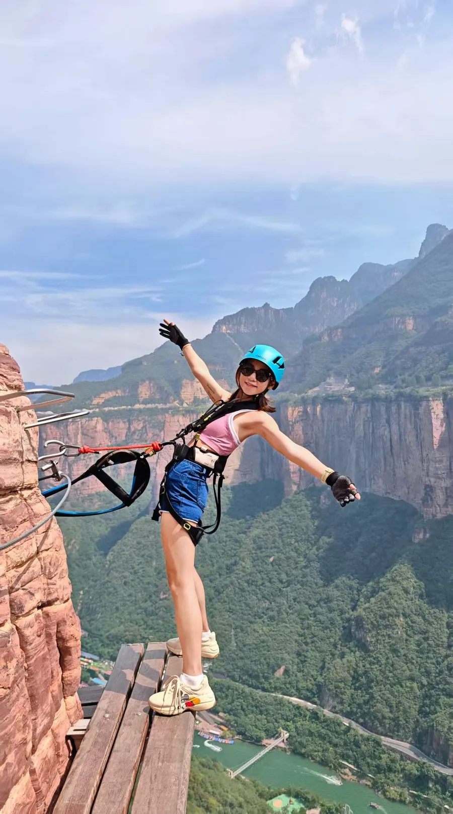 Traveler clipped into the Baoquan Via Ferrata cliff route with canyon exposure behind